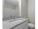 Bathroom featuring a modern granite countertop, sink, and mirror, complemented by a neutral color scheme at 7407 Sandy Creek Dr, Raleigh, NC 27615