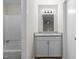 Bathroom with a gray vanity with granite top, mirror and tub/shower combo, perfect for relaxation and everyday use at 7407 Sandy Creek Dr, Raleigh, NC 27615