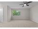 Bedroom with neutral walls, carpeted floor, ceiling fan and a large window offering a pleasant outdoor view at 7407 Sandy Creek Dr, Raleigh, NC 27615