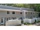 View of the townhouse featuring gray siding and a white picket fence in front of the property at 7407 Sandy Creek Dr, Raleigh, NC 27615