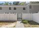 View of the townhouse exterior with white picket fence and sidewalk leading to the front door at 7407 Sandy Creek Dr, Raleigh, NC 27615
