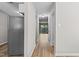 Hallway showing the refrigerator, wood-look flooring, and access to other rooms in the home at 7407 Sandy Creek Dr, Raleigh, NC 27615
