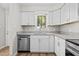 Updated kitchen with white cabinets, stainless steel appliances, and granite countertops at 7407 Sandy Creek Dr, Raleigh, NC 27615