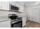 Clean kitchen with stainless steel appliances, white cabinets, and wood-look flooring at 7407 Sandy Creek Dr, Raleigh, NC 27615