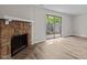 Spacious living area featuring a stone fireplace, vinyl floors, and natural light through a sliding door at 7407 Sandy Creek Dr, Raleigh, NC 27615