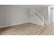 Spacious living area featuring vinyl floors and a white stairway and stone fireplace at 7407 Sandy Creek Dr, Raleigh, NC 27615