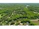 Aerial view revealing houses surrounded by dense, green trees near a small lake at 7544 Hasentree Club Dr, Wake Forest, NC 27587