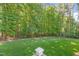 Green backyard area featuring a fenced perimeter with dense tree coverage at 7544 Hasentree Club Dr, Wake Forest, NC 27587