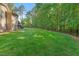 Large, well-manicured backyard featuring a fenced in perimeter and lush lawn at 7544 Hasentree Club Dr, Wake Forest, NC 27587