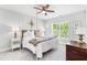 Bright bedroom with a four-poster bed, ceiling fan, and large window at 7544 Hasentree Club Dr, Wake Forest, NC 27587