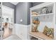 Gray entryway with hooks, a bench, storage, and view into living area at 7544 Hasentree Club Dr, Wake Forest, NC 27587