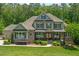 Charming two-story home with a manicured lawn, stone accents, and a welcoming front porch at 7544 Hasentree Club Dr, Wake Forest, NC 27587