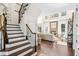 Stunning foyer featuring a grand staircase and entry to a beautiful living room with a stone fireplace at 7544 Hasentree Club Dr, Wake Forest, NC 27587