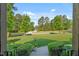 View of front yard from porch with lush, green lawn, trees and circular driveway at 7544 Hasentree Club Dr, Wake Forest, NC 27587