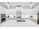Modern kitchen features sleek white cabinetry, marble countertops, stainless steel appliances, and pendant lighting at 7544 Hasentree Club Dr, Wake Forest, NC 27587