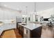 Open-concept kitchen with island, connecting seamlessly to the living and dining areas with hardwood floors at 7544 Hasentree Club Dr, Wake Forest, NC 27587