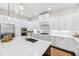 Bright kitchen features white cabinetry, marble countertops, stainless steel appliances, and a large island with a gold faucet at 7544 Hasentree Club Dr, Wake Forest, NC 27587