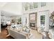 Bright living room with soaring ceilings, stone fireplace, large windows, and comfortable seating at 7544 Hasentree Club Dr, Wake Forest, NC 27587