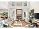 Open living room with stone fireplace, bright windows, neutral decor, and stylish furnishings at 7544 Hasentree Club Dr, Wake Forest, NC 27587