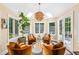 Bright sunroom with skylights, warm decor, lush plants, and stylish seating arrangement at 7544 Hasentree Club Dr, Wake Forest, NC 27587