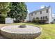 This backyard features a fire pit and view of the home's exterior and a shed at 8721 Springhouse Ln, Raleigh, NC 27617