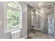 Bathroom features a tiled shower with glass door and a large window at 8721 Springhouse Ln, Raleigh, NC 27617