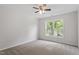 This bedroom features neutral carpet, a ceiling fan, and a bright window for plenty of natural light at 8721 Springhouse Ln, Raleigh, NC 27617