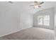 This bedroom features neutral walls and carpet, a ceiling fan, and a window at 8721 Springhouse Ln, Raleigh, NC 27617