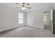 This carpeted bedroom includes a window, closet, ceiling fan, and a view of another room at 8721 Springhouse Ln, Raleigh, NC 27617