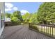 Wooden deck offers a beautiful view of trees and nature under a partly cloudy blue sky at 8721 Springhouse Ln, Raleigh, NC 27617