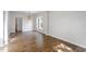 Dining room with hardwood floors, modern lighting, and a view into the living area at 8721 Springhouse Ln, Raleigh, NC 27617