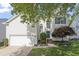 Charming two-story home featuring an attached garage, a manicured lawn, and mature landscaping at 8721 Springhouse Ln, Raleigh, NC 27617