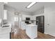 Modern kitchen with white cabinets, stainless appliances, an island, and hardwood floors at 8721 Springhouse Ln, Raleigh, NC 27617