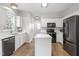 Modern kitchen with white cabinets, stainless appliances, an island, and hardwood floors at 8721 Springhouse Ln, Raleigh, NC 27617