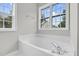 Relaxing bathroom with a deep soaking tub, elegant faucet, and windows showcasing the scenery at 8820 Waynick Dr, Raleigh, NC 27617