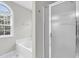 Bright bathroom featuring a glass shower, a garden tub, and a window at 8820 Waynick Dr, Raleigh, NC 27617