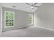 Spacious bedroom featuring vaulted ceiling, ceiling fan, neutral paint, carpet and multiple windows at 8820 Waynick Dr, Raleigh, NC 27617