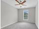 This bedroom features neutral walls, a ceiling fan, carpet flooring and a window at 8820 Waynick Dr, Raleigh, NC 27617
