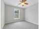 Bright bedroom featuring neutral walls, carpet flooring, a window, and a ceiling fan at 8820 Waynick Dr, Raleigh, NC 27617