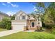 Charming two-story home with a well-maintained lawn, attached garage, and classic architectural details at 8820 Waynick Dr, Raleigh, NC 27617