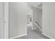 Bright hallway featuring neutral paint, carpet and a glimpse into the spacious rooms beyond at 8820 Waynick Dr, Raleigh, NC 27617