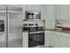 Modern kitchen with stainless steel appliances, range hood, and sleek countertops at 8820 Waynick Dr, Raleigh, NC 27617
