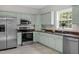 Spacious kitchen featuring stainless steel appliances and light green cabinetry at 8820 Waynick Dr, Raleigh, NC 27617