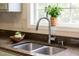 Close-up of the kitchen sink and faucet area with garden window above at 8820 Waynick Dr, Raleigh, NC 27617