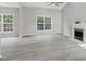Spacious living room featuring hardwood floors, a fireplace, large windows and lots of natural light at 8820 Waynick Dr, Raleigh, NC 27617