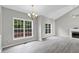 Spacious living room featuring a fireplace, large windows, and a view of the backyard at 8820 Waynick Dr, Raleigh, NC 27617