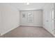 Well-lit bedroom with neutral carpet, window with blinds, and fresh paint at 904 Palm Ct, Mebane, NC 27302