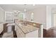 Granite kitchen island with stainless steel sink overlooks the living room and gas fireplace at 904 Palm Ct, Mebane, NC 27302