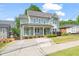 Charming two-story home with a covered front porch, lush lawn, and a paved driveway at 905 E Lenoir St, Raleigh, NC 27610