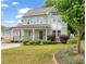 Beautiful two-story home with green siding, well-manicured landscaping, and a covered front porch at 905 E Lenoir St, Raleigh, NC 27610